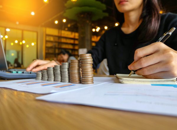 Close up of yong asian female business owner making calculations. Savings, finances and economy concept