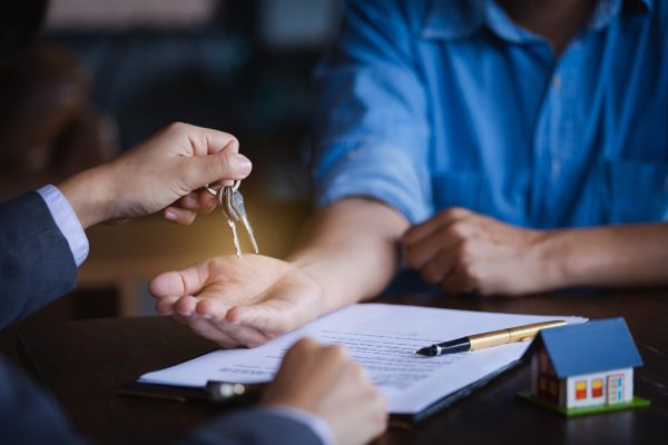 Real-estate agent giving keys to new property owners after signing contract,concept agreement and Real estate concept.real estate, moving home or renting property.